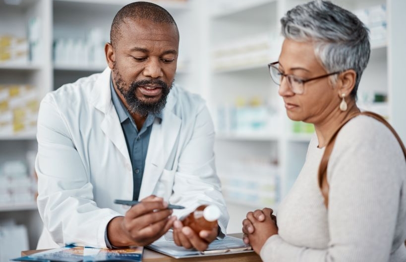 Pharmacy, black man and woman with healthcare medicine and conversation for instructions.