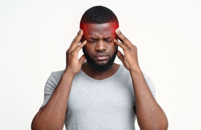 Black man holding temples due to migraine